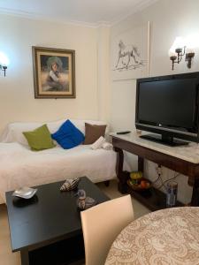 uma sala de estar com uma televisão de ecrã plano e um sofá em Apartamento Bajo A Avenida de las Yedras em Benalmádena