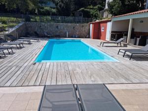 a swimming pool with chairs and a wooden deck at Hôtel Casa di Mama in Porto-Vecchio
