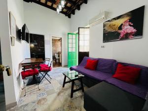 a living room with a purple couch and a piano at Apartamentos Jerez in Jerez de la Frontera