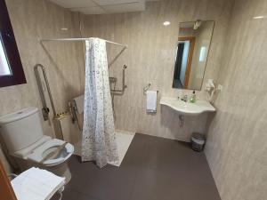 a bathroom with a toilet and a sink and a shower at Aparthotel El Faro in Cullera