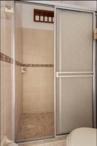a shower with a glass door in a bathroom at La Arboleda del Rio. in Cali