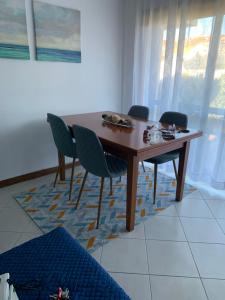 uma mesa de madeira e cadeiras num quarto em My Little Beach House em Praia da Barra