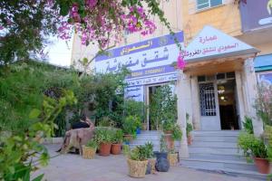 a man sitting in front of a building at Al Seoudi Furnished Units in Az Zarqa