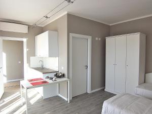 a room with a desk and a bed and a kitchen at B&B Vinago Belvedere in Mornago