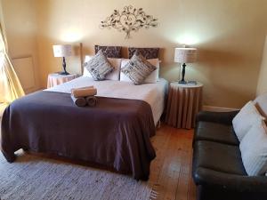 a bedroom with a large bed and a couch at Karoo Manor Guesthouse and Restaurant in Richmond