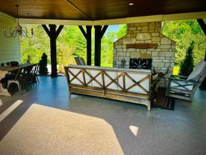 eine Terrasse mit einem Steinkamin sowie einem Tisch und Stühlen in der Unterkunft The Nest at Cardinal Hill Dahlonega in Dahlonega