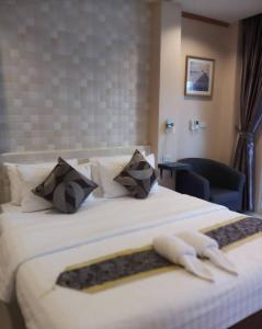 4 Palms Resort في بانغ ساري: غرفة فندق عليها سرير وفوط