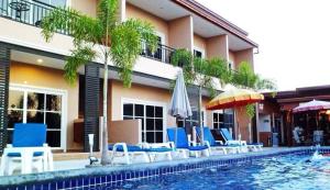 4 Palms Resort في بانغ ساري: مسبح وكراسي ومظلات بجانب مبنى