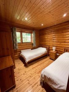 1 dormitorio con 2 camas en una cabaña de madera en Solid Log Cabin With Private Hot Tub - Oak, en Aymestrey