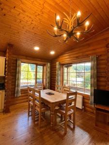 comedor con mesa y sillas en una cabaña en Solid Log Cabin With Private Hot Tub - Oak, en Aymestrey