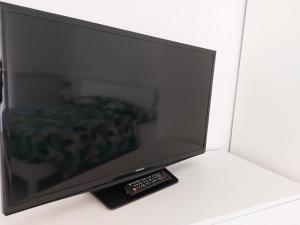 a television with a remote control next to a bed at B&B Villa Mia in Lanciano