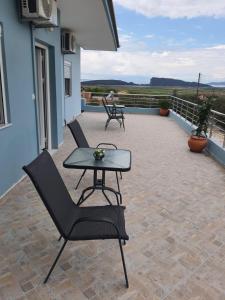 a patio with two chairs and a table on a roof at Pame Apartments in Valanidorachi
