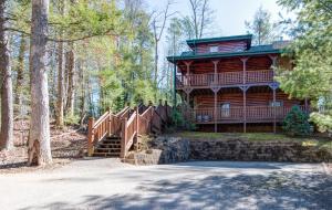 a large log cabin with a staircase leading up to a house at Hemlock Manor in Gatlinburg