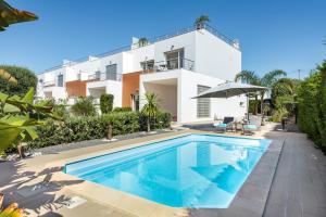 a villa with a swimming pool in front of a building at Casa Jacadi Luxury Villa, Private Pool, Rooftop terrace with sea View! in Armação de Pêra