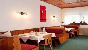 a dining room with two tables and chairs and avertisement at Pension Kristall in Neustift im Stubaital