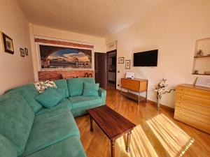 Una sala de estar con un sofá verde y una mesa. en Edel House Ostia, en Lido di Ostia