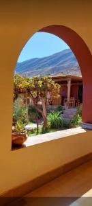 an arched window in a building with plants at El Convento de Tilcara in Tilcara