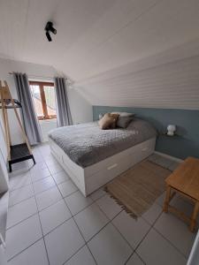 a bedroom with a bed and a tiled floor at Le Louis Vakantiehuis in Lanaken