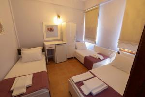 um pequeno quarto com 2 camas e uma janela em Cunda Pera Otel em Ayvalik