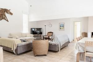 ein Wohnzimmer mit Sofa und Fernseher in der Unterkunft villa piscine chauffée 10pers dans cadre exceptionnel-AG19 in Lacanau