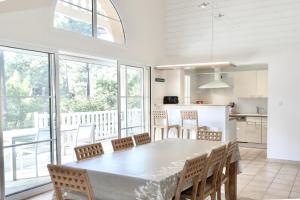 eine Küche und ein Esszimmer mit einem Tisch und Stühlen in der Unterkunft villa familiale dans cadre exceptionnel, piscine chauffée-AG19 in Lacanau