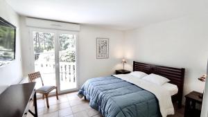 ein Schlafzimmer mit Bett, Schreibtisch und Fenster in der Unterkunft villa piscine chauffée 10pers dans cadre exceptionnel-AG19 in Lacanau + 29 Fotos