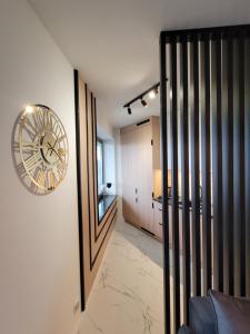a living room with a clock on the wall at ApartPort nowoczesne apartamenty in Gdynia