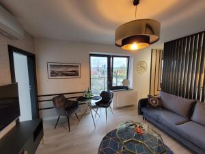 a living room with a couch and a table and chairs at ApartPort nowoczesne apartamenty in Gdynia
