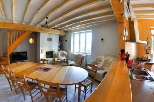 eine Küche und ein Wohnzimmer mit einem Holztisch und Stühlen in der Unterkunft Maison chaleureuse au cœur du perche sarthois in Bessé-sur-Braye