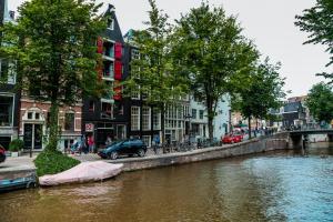 Un río con un barco en medio de una ciudad en International Budget Hostel City Center en Ámsterdam