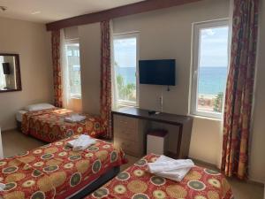 a hotel room with two beds and a television at Rosella Hotel in Alanya