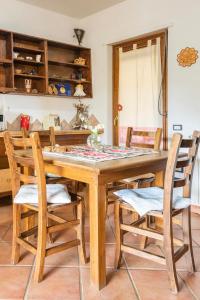 una sala da pranzo con tavolo e sedie in legno di B&B Su Biancu - Sardinian Experience a Urzulei