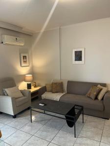 ein Wohnzimmer mit einem Sofa und einem Couchtisch in der Unterkunft Athens Riviera modern apartment in Piräus