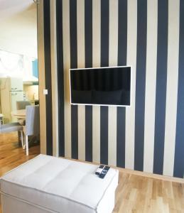 um quarto com uma televisão numa parede listrada em Maison De Prestige em Chalkida
