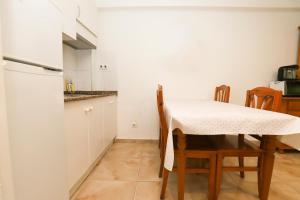 cocina con mesa, sillas y nevera en DIFFERENTFLATS Acantilados, en Salou
