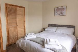 a bedroom with a bed with two towels on it at City Centre Riverview Apartment in Derry Londonderry