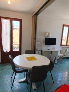 ein Zimmer mit Tisch, Stühlen und Fernseher in der Unterkunft Venice lagoon suite in Chioggia + 39 Fotos