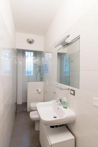 W łazience znajduje się umywalka, toaleta i lustro. w obiekcie MILAN stilysh apartment near Metro and Fiera MICO w Mediolanie