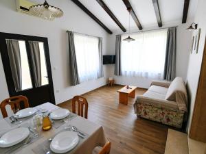 uma sala de estar com uma mesa e um sofá em Holiday Home, Apartment and Rooms Milica em Mošćenička Draga