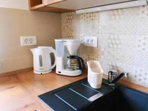 um balcão de cozinha com comodidades para preparar café e um lavatório em Holiday Home, Apartment and Rooms Milica em Mošćenička Draga
