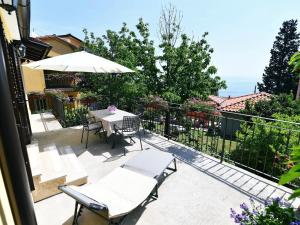 a patio with a table and chairs and an umbrella at Holiday Home, Apartment and Rooms Milica in Mošćenička Draga