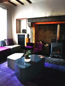 a living room with a couch and a fireplace at Chez Kahina ancien hôtel Robert in Giat