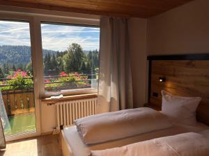 a bedroom with a bed and a large window at Boutique Hotel and Apartments Pension Sternen in Todtmoos