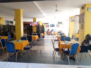 a dining room with tables and chairs and people eating at DOUBLE FIVE HOTEL in Kampala