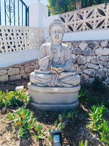 a statue of a buddha sitting in a garden at 1-Bed Apartment close to Moraira town centre in Moraira