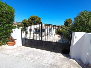 a black gate in front of a white fence at 1-Bed Apartment close to Moraira town centre in Moraira