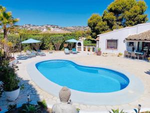 a swimming pool in the middle of a yard at 1-Bed Apartment close to Moraira town centre in Moraira