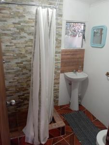 a bathroom with a shower curtain and a sink at Hermoso Domo privado para 2 personas con tinaja-Cochiguaz Valle De Elqui in Paihuano