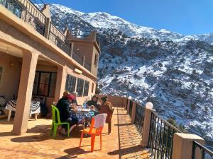 a group of people sitting at a table on a balcony with a mountain at Gite Gliz in Marrakech