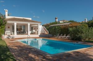 a swimming pool in front of a house at Resort Villas Andalucia in Benalup Casas Viejas